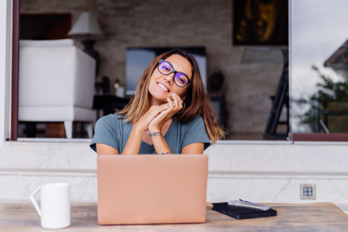 happy-caucasian-woman-does-distance-work-laptop-home-comfortable-place-drinking-tea